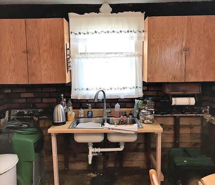 small kitchen with a freestanding sink and old cabinets