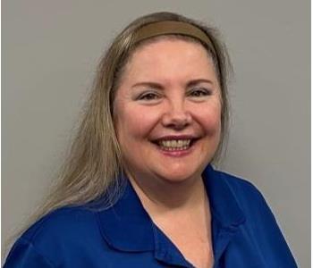 Woman with blonde hair and a blue shirt with a SERVPRO logo on it