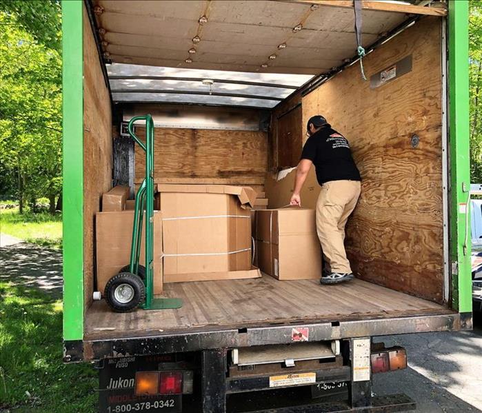 man with a servpro shirt on unloading large boxes out of a truck