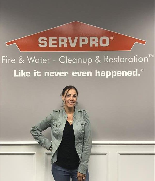 Woman standing in front of a SERVPRO sign