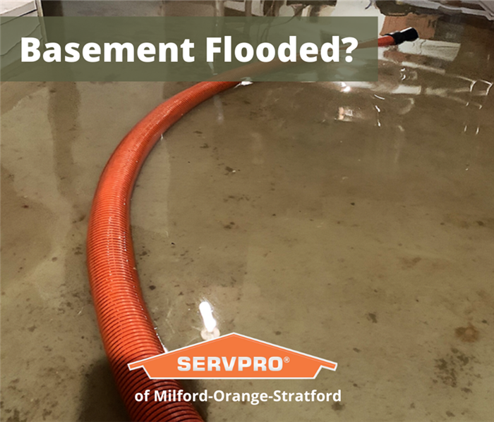 flooded basement with orange hose running through it